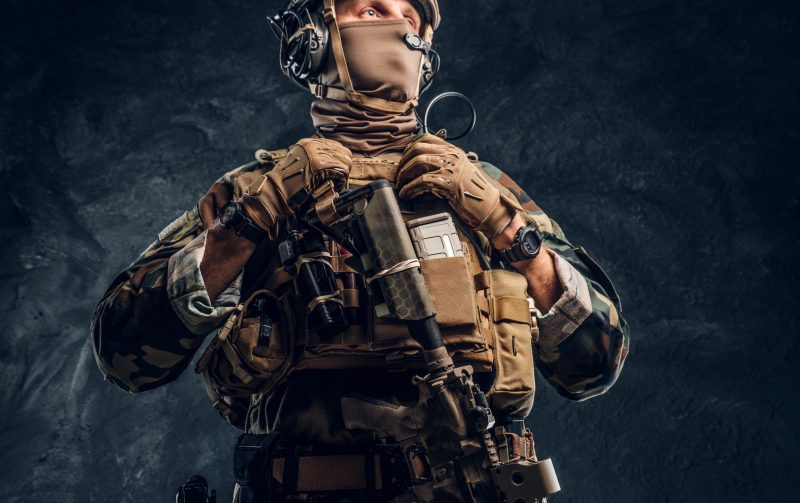 Elite unit, special forces soldier in camouflage uniform. Studio photo against a dark textured wall