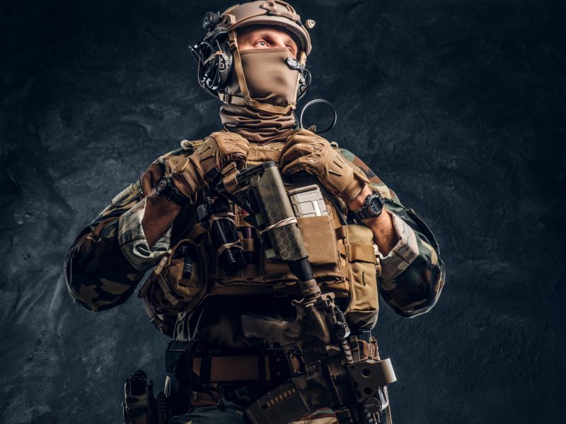 Elite unit, special forces soldier in camouflage uniform. Studio photo against a dark textured wall